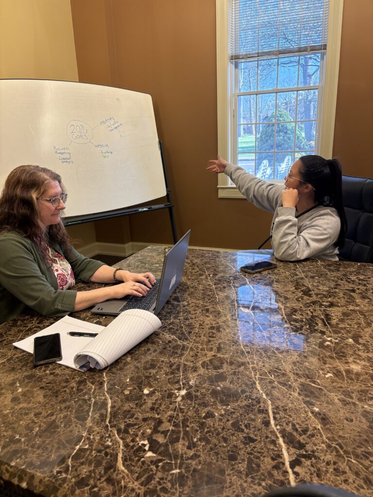 An advisor and business owner planning at a whiteboard